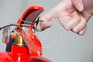 Close- up Fire extinguisher and pulling pin on red tank.