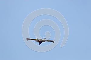 Close up of a fire fighting water bomber airplane flying over head, dropping water on wildfires in Croatia. Flying slowly with its