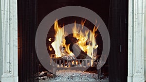 A close up fireplace showing logs and coal burning