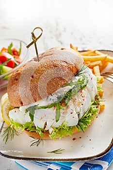 Close-up of fish burger served with French fries
