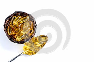 Close-up of fish oil capsules in a spoon and basket on a white background. Omega 3 capsules - natural vitamins.