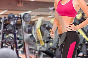Close up of fit woman showing thumbs up over gym
