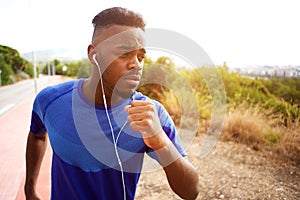 Close up fit young black man running with earphones