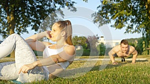 CLOSE UP: Fit young Caucasian couple working out together in the sunny nature.