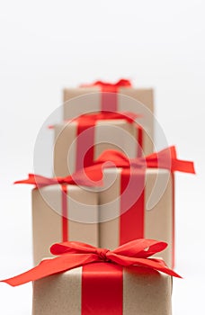 Close-up brown paper gift box red bow ribbon white background. concept for happy love gift