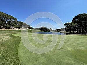 Golf green on a lake with blue sky