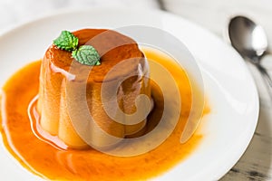 Close up of a flan creme caramel pudding with mint, a custard dessert.