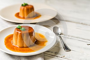 Close up of a flan creme caramel pudding with mint, a custard dessert.