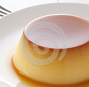 Close up of flan on white plate created using generative ai technology