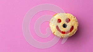 Close up flat lay of yellow smiley happy face donut isolated on