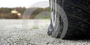 Close-up of Flat rear tire on car. The right rear broken weel. Damaged rear wheels on parking place