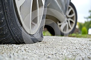 Close-up of Flat rear tire on car. The right rear broken weel. Damaged rear wheels on parking place