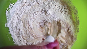 Close-up of flour mixed with eggs using a whisk to mix bakery ingredients. Beat the egg yolk of flour and milk close up. The proce