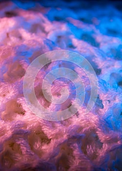 Close-up of fluffy soft textile. Abstract fabric with knit texture for background