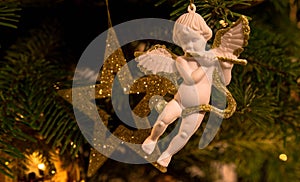 Vista de cerca de ángel colgante sobre el árbol de navidad bebé estrella en. 