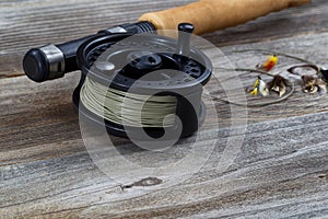 Close up of Fly Reel and Flies on Wood