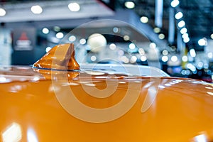 Close up of an FM AM GPS Navigation antenna placed on the roof of a vehicle.  Blurry defocused background