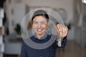 Close up focus on keys in happy Indian woman hand