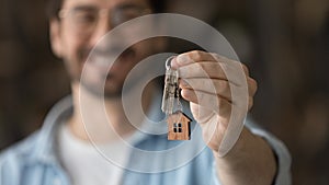 Close up focus on keys, satisfied man excited by relocation