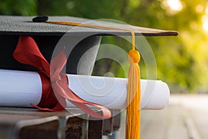 Close up focus of university graduate holds degree certificate and graduation cap celebrates in the  graduation ceremony. photo