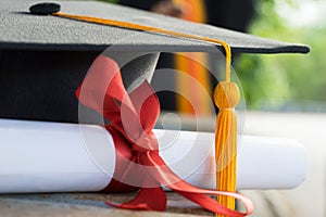 Close up focus of university graduate holds degree certificate and graduation cap celebrates in the  graduation ceremony.