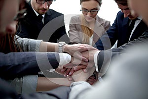 Close up.a focused business team putting their hands together