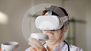 Close-up of focused Caucasian female doctor practicing in augmented reality using VR headset. Portrait of professional