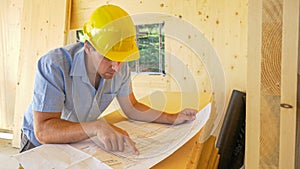 CLOSE UP: Focused contractor analyzes the floor plans of a modern CLT house.