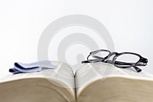 Close-up of folded reading glasses and a microfiber cloth
