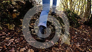 Close up follow shot of female boots walk in middle of small mountain trail in forest.