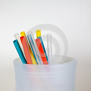 A close up of a food-grade silicone bag holding different colored reusable, silicone straws, a plastic alternative