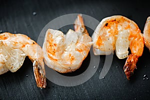 Close up food photo of fried shrimps on black slate background. Asian culture and cuisine. Food image of prawn for design of cafe,