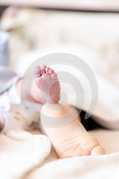 Close-up of the foot of a newborn baby and a one-year-old baby. Feet of infants of different ages sleeping. Foot of a