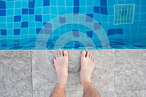 Close up foot of sport man standing beside swimming pool