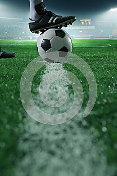 Close up of foot on top of soccer ball on the line, side view, stadium