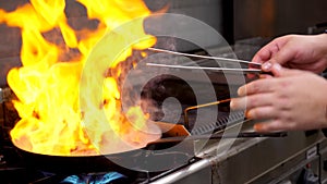 Close up footage of cook frying duck breast meat with open flame