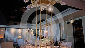 Close up footage of restaurant filled with tables and chairs and candles on them. Wedding event