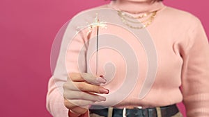 Close up footage of woman hands golding sparkling light in studio