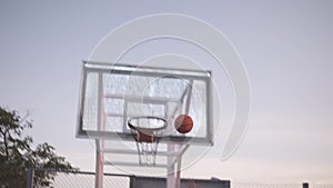 Close up footage of a young girl basketball player training and exercising outdoors on the local court. Dribbling with