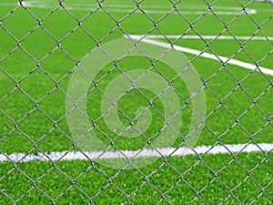 Close up of football field behind chain link fence