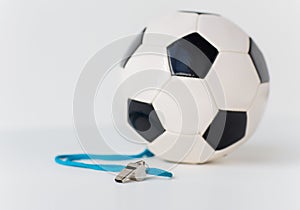 Close up of football or soccer ball and whistle