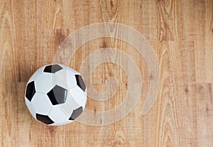 Close up of football or soccer ball on wood