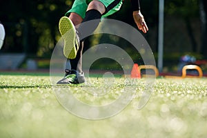 Close up footballer feet kicking ball on grass. Soccer player kicking ball on field. Soccer players on training session.