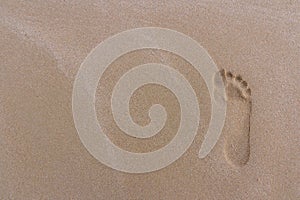 Close up footprints on sand beach in the morning during summer v