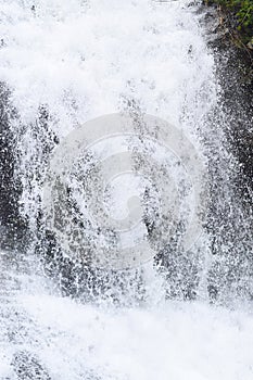 Close up of Forceful Flow of Water with Sprinkling of White Drops photo