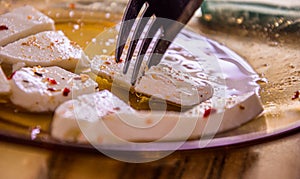 Close up of a fork slicing white flavored cheese