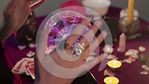 Close up of fortune teller performing ritual and crystal ball foreseeing future