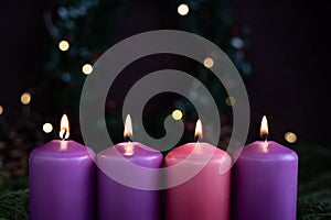 Close-up of four burning purple advent candles