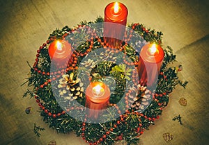 Close up of four red candles burning on advent wreath on evening. Merry Christmas, Advent crown decoration, 4th sunday, Christmas