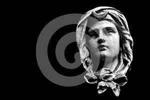 Close up fragment of an ancient stone statue of Virgin Mary. Isolated on black background. Copy space
